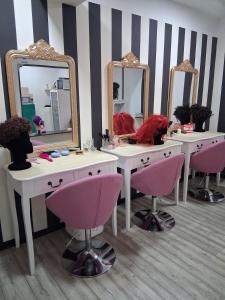 a bathroom with two sinks with mirrors and pink chairs at Le studio de Jazzy in Fécamp