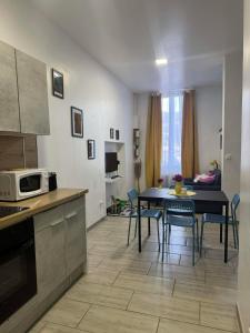 a kitchen and living room with a table and chairs at Le studio de Jazzy in Fécamp