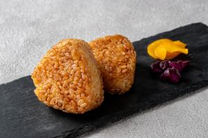two pieces of food sitting on a black plate at Hotel Flower Style koriyama tenri in Tenri
