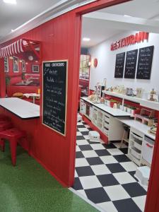 a restaurant with red walls and a checkered floor at Le studio de Jazzy in Fécamp