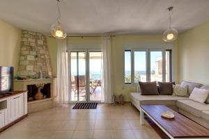 a living room with a couch and a fireplace at Hemera House Posidi H3 in Possidi