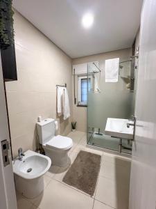 a bathroom with a toilet and a sink and a shower at Casa Rosa in Parede +29 photos