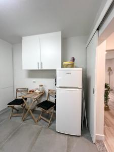 a kitchen with a white refrigerator and a table at Casa Rosa in Parede