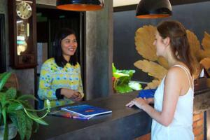 a woman standing at a counter talking to a girl at Rakkawan Residence - SHA EXTRA PLUS in Khao Lak