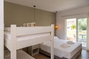 a white bunk bed in a room with a mirror at Hotel Elina in Perdika