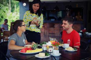 a group of people sitting at a table with food at Rakkawan Residence - SHA EXTRA PLUS in Khao Lak