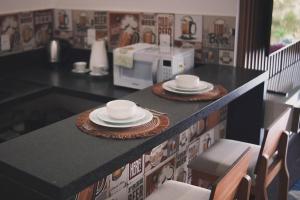 a kitchen counter with two plates and a microwave at Chalés Mirante da Colina in Venda Nova do Imigrante