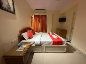 a bedroom with a bed with a desk and red pillows at KANCHAN DEEP in Jaipur