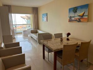 a living room with a table and chairs and a couch at Vizinho dos Parapente - Novo Luxo apartamento in Canoa Quebrada