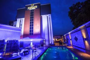 a swimming pool in front of a hotel at night at Joygate Hotels & Suites in Lagos