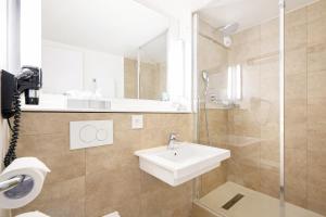 a bathroom with a sink and a shower at Kyriad Bordeaux - Merignac Aéroport in Mérignac +39 photos