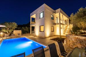 a villa with a swimming pool at night at Villa Mauro in Božava