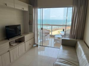 a living room with a couch and a view of the ocean at Vizinho dos Parapente - Novo Luxo apartamento in Canoa Quebrada