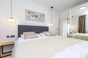 a white bedroom with a large white bed and mirrors at Villa Mauro in Božava +32 photos