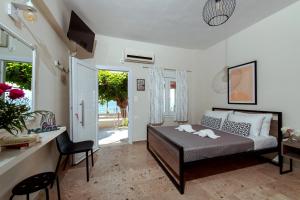 a bedroom with a bed and a table and chairs at Moukas Seaside Apartments Romantico in Selianitika