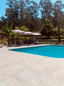 a swimming pool with umbrellas and chairs at Casa Aurora in Perelhal