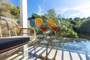 two glasses of wine on a glass table on a balcony at Villa Mauro in Božava