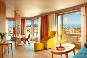 a living room with a yellow chair and a table at Zeus Wyndham Grand Athens in Athens