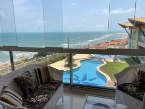 a room with two chairs and a view of the ocean at Vizinho dos Parapente - Novo Luxo apartamento in Canoa Quebrada