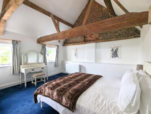 a bedroom with a white bed and a desk at Kingfisher Barn in Abingdon