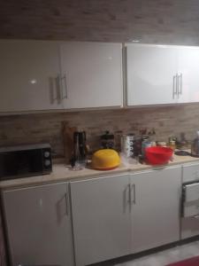 a kitchen with white cabinets and a yellow bowl on the counter at Al Sawy Station in Cairo