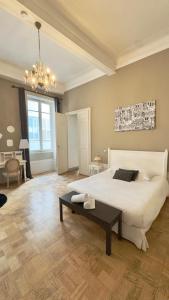 a bedroom with a large white bed and a table at Les Suites de Sautet - Chambéry centre in Chambéry