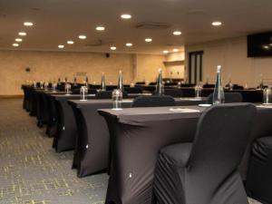 a row of tables and chairs in a conference room at Q's Evander Hotel & Apartments in Evander +26 photos