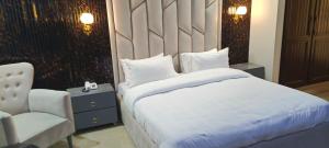 a bedroom with a white bed and a chair at Sonnet Inn Guest House in Dargai +17 photos