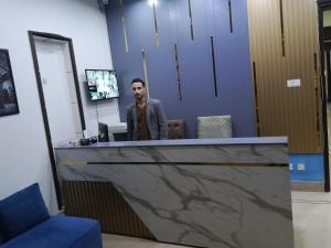 a man standing at a reception desk in an office at Sonnet Inn Guest House in Dargai