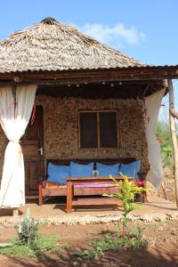 a hut with a bench in front of it at Bahati Diani House Glamping in Diani Beach