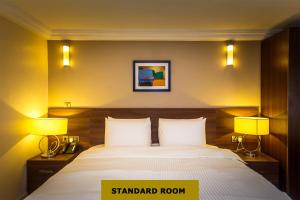 a hotel room with a bed and two lamps at Joygate Hotels & Suites in Lagos +13 photos