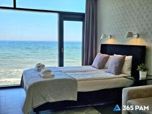 a bedroom with a bed with a view of the ocean at 365PAM - Boulevard Z Widokiem Na Morze in Ustronie Morskie