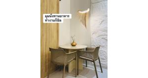 a table and chairs in a room with a wall at 24Rooms นครสวรรค์ in Nakhon Sawan