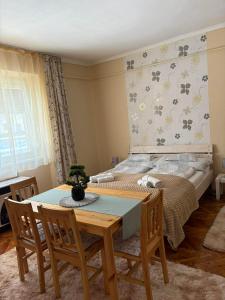 a dining room with a table and a bed at Csilla Apartman in Makó +33 photos