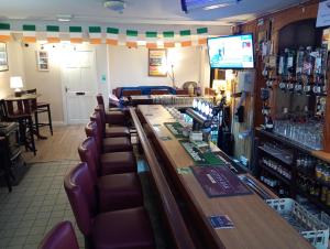 a bar in a restaurant with leather chairs at Matty's Pub - Apartment's in Carlow