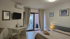 a bedroom with a bed and a desk and a computer at Open space centrale con parcheggio privato coperto in Palau