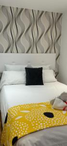 a bedroom with a white bed with a yellow blanket at Gibraltar Luxe Stay 1403 in Gibraltar