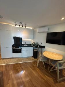 a kitchen with a desk and a table and a television at Gibraltar Luxe Stay 1403 in Gibraltar