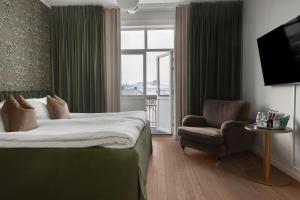 a hotel room with a bed and a chair and a window at Grand Hotel Jonkoping, BW Signature Collection in Jönköping