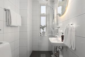 a white bathroom with a sink and a mirror at Grand Hotel Jonkoping, BW Signature Collection in Jönköping +59 photos
