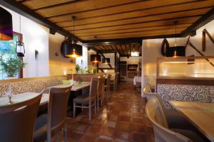 a restaurant with wooden ceilings and tables and chairs at Land-gut-Hotel Räuber Lippoldskrug in Alfeld