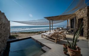a patio with a hammock and the ocean at Inkaterra Cabo Blanco in Talara
