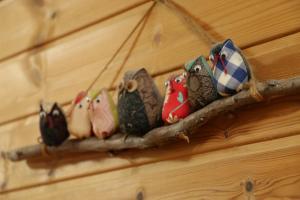 a group of owls sitting on a branch on a wall at Minshuku Asogen in Aso