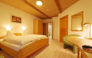 a bedroom with a large bed and a desk and a desk at Land-gut-Hotel Räuber Lippoldskrug in Alfeld +18 photos