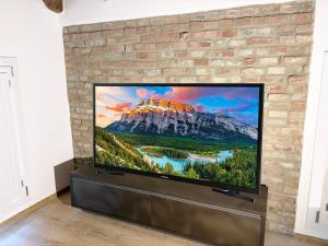 a flat screen tv sitting against a brick wall at Ugo Bassi 98 in Cento