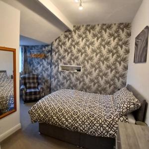 a bedroom with a bed with a patterned wall at Bagshaw Bed & Breakfast in Bridlington