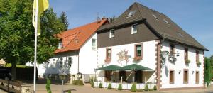 a large white building with a black roof at Land-gut-Hotel Räuber Lippoldskrug in Alfeld