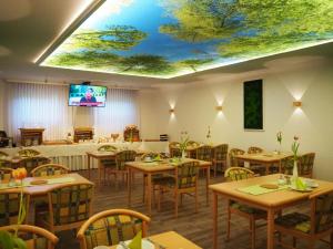 a dining room with tables and a tv on a ceiling at Land-gut-Hotel Räuber Lippoldskrug in Alfeld