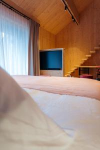a bedroom with a bed and a flat screen tv at Le Relais D'Orti in Sainte-Ode