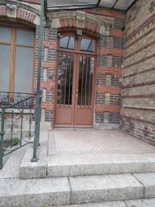 a red door on a brick building with stairs at Studio Danton in Troyes